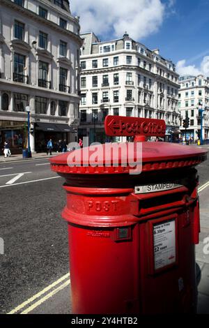 Ein klassischer roter Briefkasten steht an der Regent Street, umgeben von geschäftigen Straßen und Geschäften in Westminster, London. Stockfoto