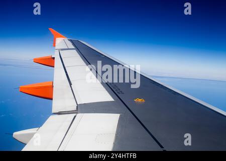 Ein Flügel erstreckt sich über die weite blaue Weite und zeigt einen Blick auf Portugal von einem Flugzeug aus. Stockfoto