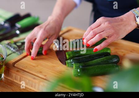 Köche Hände mit einem Messer und bereiten Speisen aus frischem, grünem Gemüse zu Stockfoto