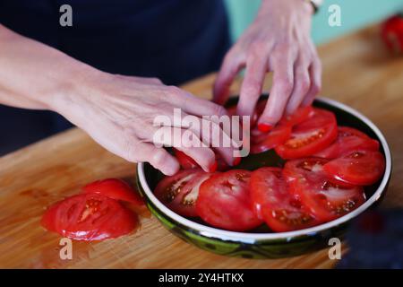 Die Köche händigen mit einem Messer, bereiten Gerichte aus frischen Tomaten zu Stockfoto