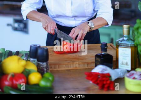 Köche Hände mit einem Messer und bereiten Lebensmittel aus frischem Gemüse zu Stockfoto