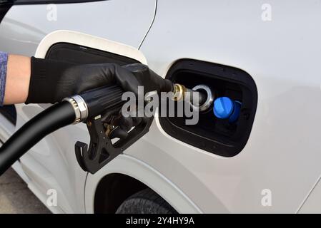 Tankpistole im Tankeinfüllstutzen. Kraftstoffdüse im Tankeinfüllstutzen. Kraftstoffpumpe in Einfüllöffnung. Stockfoto