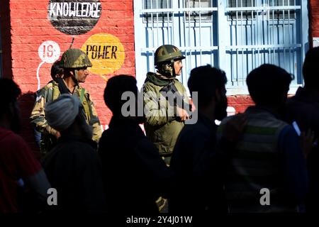 Anantnag, Jammu Und Kaschmir, Indien. September 2024. Paramilitärische Soldaten bewachen, wie kaschmirische Wähler in einer Warteschlange stehen, um ihre Stimme am Wahllokal in Kokarnag, Kaschmir, abzugeben. Indiens Kaschmir hält die ersten Regionalwahlen seit dem Verlust der Autonomie ab. Auf dem Spiel stehen Sitze in der 90-köpfigen Legislative der Region, die Gesetze erlassen und lokale Regierungsentscheidungen genehmigen wird. (Kreditbild: © Mubashir Hassan/Pacific Press via ZUMA Press Wire) NUR REDAKTIONELLE VERWENDUNG! Nicht für kommerzielle ZWECKE! Stockfoto