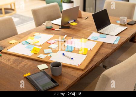 Ideen zum Brainstorming, Freunde mit Laptops und Haftnotizen auf Holztisch Stockfoto