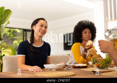 Essen Sie zu Mittag, junge Freunde sitzen am Tisch und genießen Sie gemeinsam das Essen Stockfoto