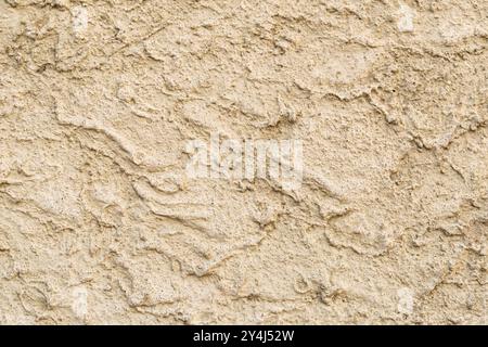 Gelber Putz an der Wand in rauem Stil, sandiger Textur, als Außenfassade verwendet. Textur von Baumaterialien Stockfoto