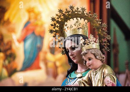 Madonna und Kinderaltar La Capilla Maria Auxiliadora Granada Nicaragua // GRANADA, Nicaragua — ein aufwendig verziertes Altarbild mit der Madonna und dem Kind steht in der Capilla Maria Auxiliadora (Kapelle Maria Hilfe der Christen) in Granada. Das reich verzierte religiöse Kunstwerk zeigt die Jungfrau Maria, die den Jesuskinder hält, ein zentrales Andachtsbild in der katholischen Anbetung. Die Kapelle, die sich in der historischen Kolonialstadt Granada befindet, repräsentiert das starke katholische Erbe, das in ganz Nicaragua noch immer vorherrschend ist. Granada wurde 1524 gegründet und ist eine der ältesten in Europa etablierten citi Stockfoto