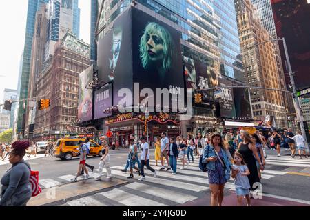 Horden von Menschen überqueren die West 42nd Street unter Werbung für die Warner Bros Pictures’ „Joker: Folie á Deux“ am Sonntag, 15. September 2024. Der Film mit Joaquin Phoenix und Lady Gaga wird am 4. Oktober 2024 veröffentlicht (© Richard B. Levine) Stockfoto