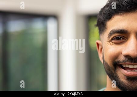 Lächelnder junger Indianer mit Bart, der die Zeit im Haus genießt, Nahaufnahme Porträt, Kopierraum Stockfoto