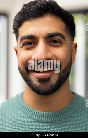 Lächelnder junger Indianer in lässigem Pullover, der in die Kamera schaut, Nahporträt Stockfoto