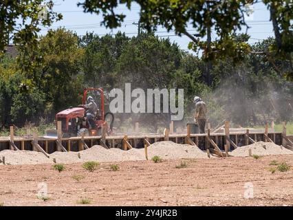 Georgetown, Texas – 10. September 2024: Gratch Witch Tractor, der die Gräben für Abflüsse in der Basis der Fundamentplatte erstellt. Stockfoto