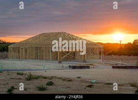 Georgetown, TX - 10. September 2024: Einfamilienhaus mit Plattenfundamenten und dimensionalen Holzrahmen und Dachfachwerkrahmen bei Sonnenuntergang Stockfoto