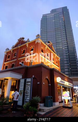 Der Blick in die Dämmerung auf den Yebisu Garden Place Tower in der Nähe des Bahnhofs Ebisu mit einem Eiscafé der Blauen Segel im Vordergrund. Ebisu, Tokio, Japan Stockfoto