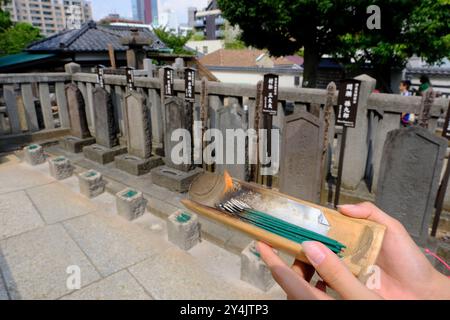 Ein Besucher, der im Sengaku-Ji-Tempel 47 Ronin of Ako als Weihrauchopfer an die Gräber des Vorfalls Ronin of Ako geopfert hat. Tokio, Japan Stockfoto