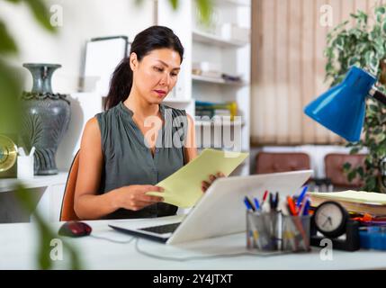 Asiatische Geschäftsfrau sitzt im Büro am Arbeitsplatz Stockfoto