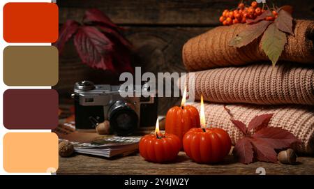 Herbstkomposition mit brennenden Kerzen in Form von Kürbis und Pullover auf hölzernem Hintergrund. Verschiedene Farbmuster Stockfoto