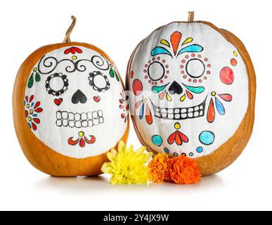 Kürbisse mit bemalten Schädeln und Blumen auf weißem Hintergrund. El Dia de Muertos Stockfoto