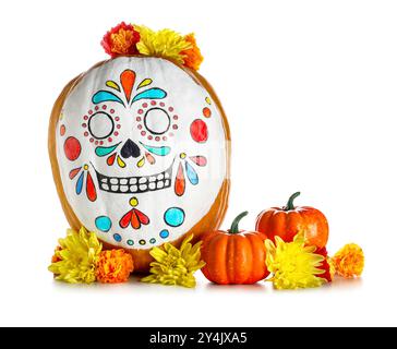 Kürbis mit bemaltem Schädel und schönen Blumen auf weißem Hintergrund. El Dia de Muertos Stockfoto