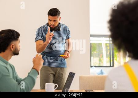 Unternehmensgründungen, Ideen diskutieren, junger Mann Gesten machen, während er mit Freunden Haftnotizen hält Stockfoto