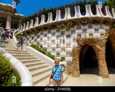 Eine Frau im Park Guel in Barcelona, Spanien, an der Treppe zum Obergeschoss Stockfoto