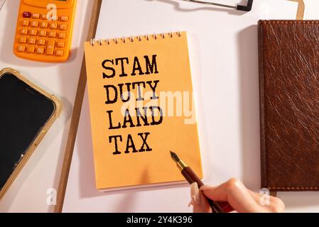 Stempel Duty Land Tax SDLT Text auf gelbem Aufkleber am Notizblock. Zahnräder, Brillen und einen weißen Stift Stockfoto