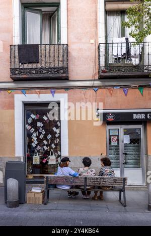 Drei Freunde versammeln sich auf einer Bank in Madrid, Spanien. Stockfoto