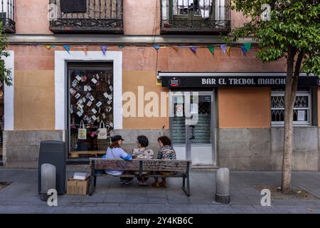 Drei Freunde versammeln sich auf einer Bank in Madrid, Spanien. Stockfoto