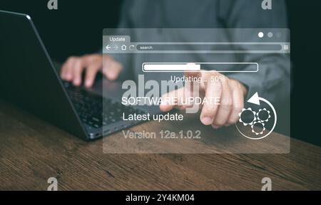 Software-Update-Konzept. Man aktualisiert und installiert Updates für Geschäftsprogramme auf einem Computer für bessere Leistung, Sicherheit und neue Funktionen Stockfoto