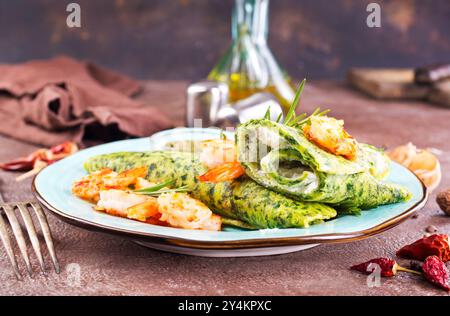 Grüne Pfannkuchen in Nahaufnahme mit Garnelenfüllung und Käse auf dunklem Hintergrund Stockfoto