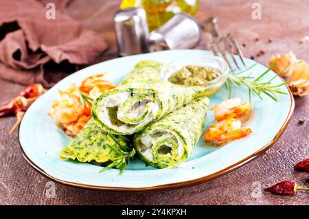 Grüne Pfannkuchen in Nahaufnahme mit Garnelenfüllung und Käse auf dunklem Hintergrund Stockfoto