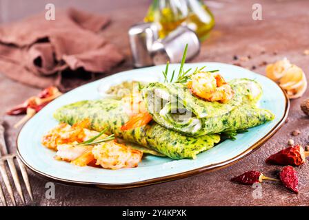 Grüne Pfannkuchen in Nahaufnahme mit Garnelenfüllung und Käse auf dunklem Hintergrund Stockfoto