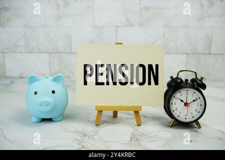 Pension Text geschrieben auf Papierkarte mit Sparfunktion und Wecker auf Marmorhintergrund Stockfoto