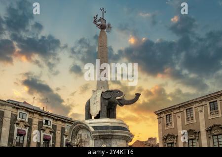 Der berühmte Elefantenbrunnen (Fontana dell'Elefante) auf der Piazza del Duomo bei Sonnenuntergang. Historisches Wahrzeichen mit dramatischem Himmel und architektonischen Details. Stockfoto