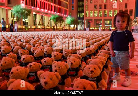 DER SYRISCHE KÜNSTLER BASHIR MUHAMMAD S KUNSTINSTALLATION IN DOHA ECHO OF LOST INNOCENCE Ein kleines Kind betrachtet eine Installation von Teddybären mit dem Titel Echo of Lost Innocence in der Freiluftgalerie Barahat Mashaireb, um auf palästinensische Kinder aufmerksam zu machen, die beim israelischen Angriff auf Gaza am 18. September 2024 in Doha, Katar, ihr Leben verloren haben. Die Installation mit 15.000 Teddybären wurde vom syrischen Künstler Basher Mohamad entworfen. DOHA Katar Copyright: XNOUSHADx Stockfoto