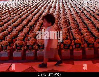 DER SYRISCHE KÜNSTLER BASHIR MUHAMMAD S KUNSTINSTALLATION IN DOHA ECHO OF LOST INNOCENCE Ein kleines Kind betrachtet eine Installation von Teddybären mit dem Titel Echo of Lost Innocence in der Freiluftgalerie Barahat Mashaireb, um auf palästinensische Kinder aufmerksam zu machen, die beim israelischen Angriff auf Gaza am 18. September 2024 in Doha, Katar, ihr Leben verloren haben. Die Installation mit 15.000 Teddybären wurde vom syrischen Künstler Basher Mohamad entworfen. DOHA Katar Copyright: XNOUSHADx Stockfoto