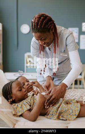 Krankenschwester, die Kleinkinder in der medizinischen Einrichtung behandelt Stockfoto