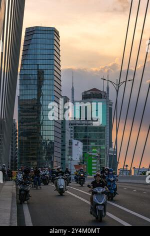 Blick auf den Sonnenuntergang von Motorrädern, die am 13. Mai 2023 in Ho Chi Minh City, Vietnam, auf der Ba Son Bridge, einem beliebten Wahrzeichen entlang des Saigon River, fahren Stockfoto