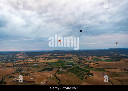 Blick aus der Vogelperspektive auf das Yarra Valley bei Sonnenaufgang (mit mehreren Heißluftballons in Sicht), aufgenommen von der Heißluftballonfahrt, Victoria, Australien Stockfoto