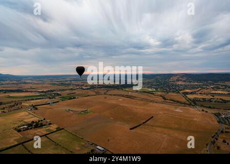 Blick aus der Vogelperspektive auf das Yarra Valley bei Sonnenaufgang (ein Heißluftballon in Sicht), aufgenommen von einer Fahrt im Heißluftballon, Victoria, Australien Stockfoto