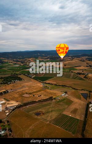 Blick aus der Vogelperspektive auf das Yarra Valley bei Sonnenaufgang (ein Heißluftballon in Sicht), aufgenommen von der Heißluftballonfahrt, Victoria, Australien Stockfoto