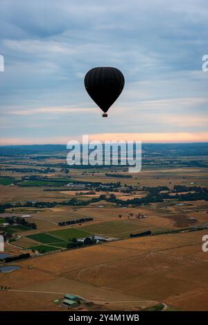 Blick aus der Vogelperspektive auf das Yarra Valley bei Sonnenaufgang (ein Heißluftballon in Sicht), aufgenommen von der Heißluftballonfahrt, Victoria, Australien Stockfoto