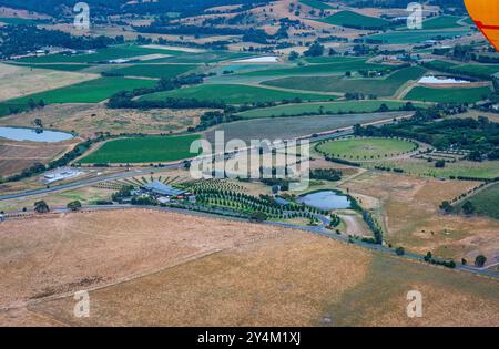 Blick aus der Vogelperspektive auf das Yarra Valley bei Sonnenaufgang (ein Heißluftballon in Sicht), aufgenommen von einer Fahrt im Heißluftballon, Victoria, Australien Stockfoto