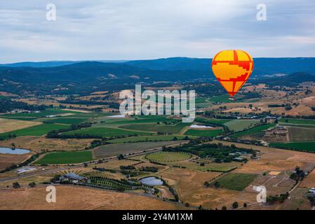 Blick aus der Vogelperspektive auf das Yarra Valley bei Sonnenaufgang (ein Heißluftballon in Sicht), aufgenommen von einer Fahrt im Heißluftballon, Victoria, Australien Stockfoto