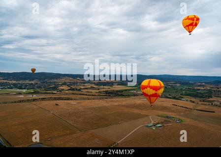 Blick aus der Vogelperspektive auf das Yarra Valley bei Sonnenaufgang (mit mehreren Heißluftballons in Sicht), aufgenommen von der Heißluftballonfahrt, Victoria, Australien Stockfoto