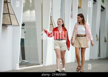 Mit Freunden an den Schaufenstern im urbanen Umfeld vorbeispazieren Stockfoto