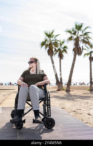 Frau über 60 Jahre alt im Rollstuhl am Strand Stockfoto