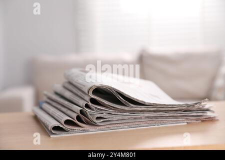 Stapel Zeitungen in verschiedenen Sprachen auf dem Tisch drinnen Stockfoto