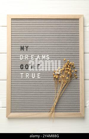 Brieftafel mit dem Satz My Dreams Come wahre und trockene Pflanzen auf weißem Holztisch, Blick von oben Stockfoto