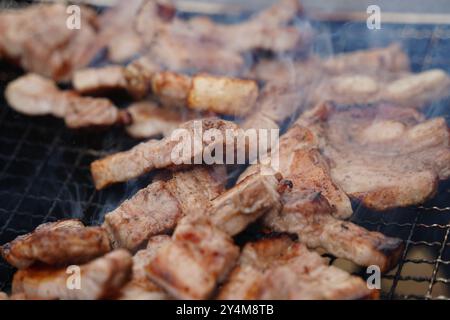 Nahaufnahme des Schweinebauchs, der auf einem Holzkohlegrill gegrillt wird. Stockfoto