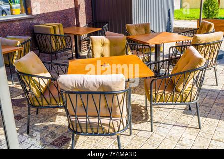 Charmante und gemütliche Sitzplätze im Café im Freien, mit gepolsterten Stahlstühlen für ultimativen Komfort Stockfoto